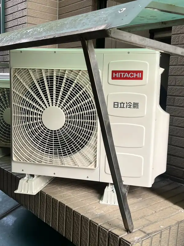 完工：日立室外機架設於雨遮下方平台，下方加裝腳墊