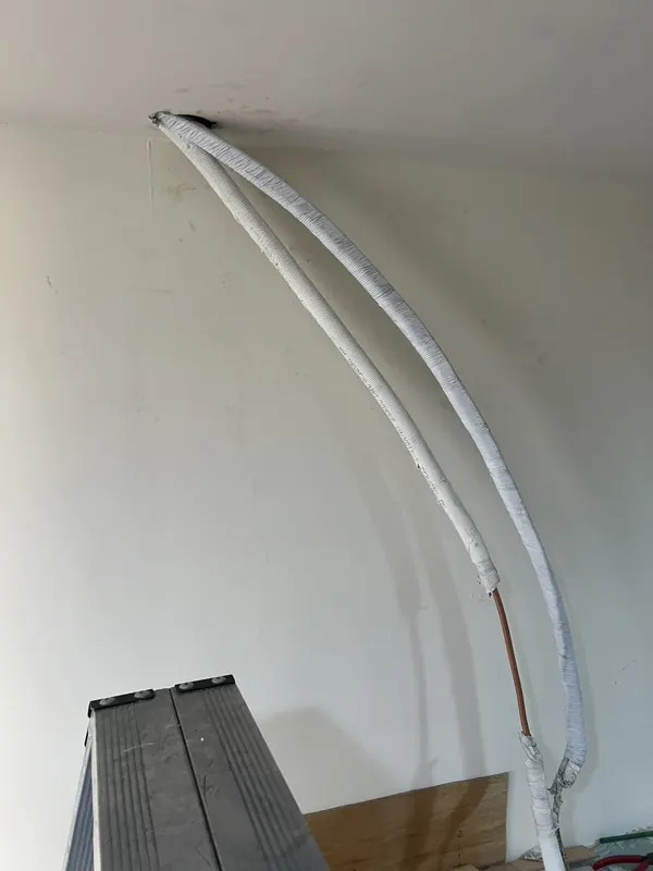 施工中：新冷媒管自天花板開口拉出，保溫材包覆